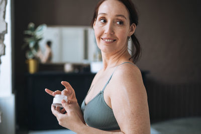 Portrait of young woman sitting at home