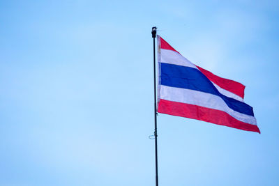 Low angle view of flag against blue sky