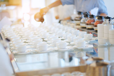 Midsection of person pouring tea in cups