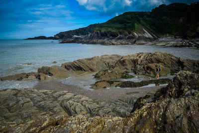 View out to sea from rocky coastline against blue sea and sky at hele bay, ilfracombe