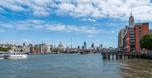 Bridge over river in city against sky