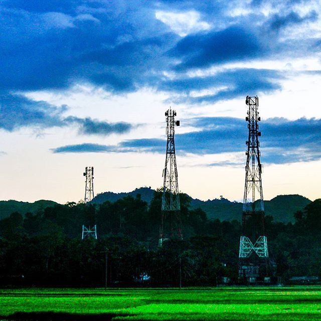 sky, fuel and power generation, technology, cloud - sky, electricity pylon, built structure, building exterior, landscape, wind power, electricity, field, cloud, architecture, tree, alternative energy, environmental conservation, renewable energy, windmill, wind turbine, rural scene