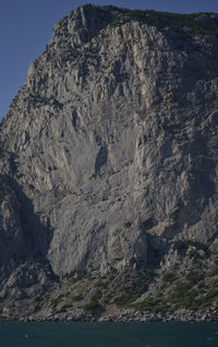 Rock formations by sea against sky