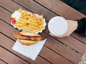  view of french fries and bratwurst and coffee on table 