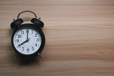 Close-up of clock on wooden wall