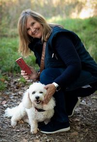 Portrait of woman with dog on field