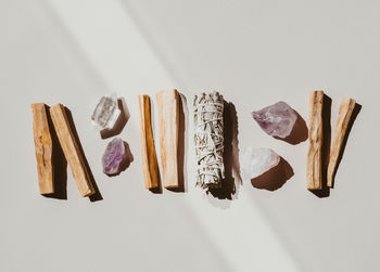 White sage and palo santo and amethyst and quartz crystals on a light beige background