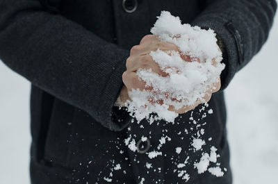 Midsection of person holding ice during winter