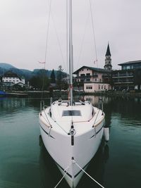 Boats moored in water against sky