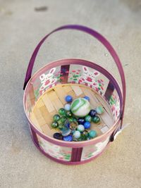 High angle view of multi colored glass marbles in bowl on table