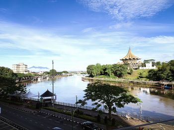 Dewan undangan negeri sarawak. river by buildings against sky in city
