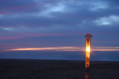 Scenic view of beach against sky at sunset