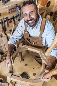 Portrait of smiling carpenter working in workshop