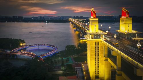 Illuminated bridge over river at night