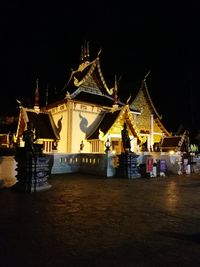 Illuminated traditional building against sky at night