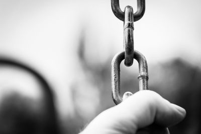 Close-up of hand holding chain