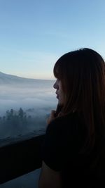 Portrait of woman standing on mountain against sky