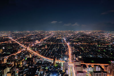 High angle view of city lit up at night