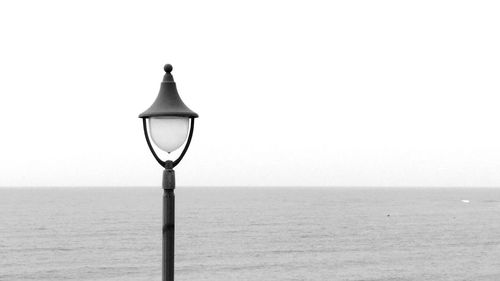 Street light on beach against clear sky