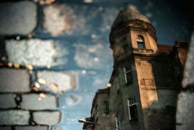 Historic building reflecting on puddle