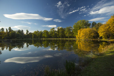 Scenic view of lake by trees against sky