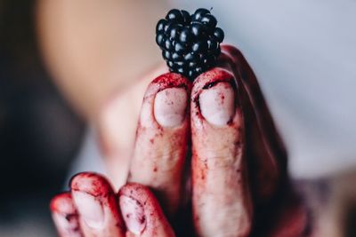 Cropped image of dirty hand holding blackberry