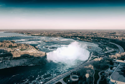 High angle view of city by river against sky