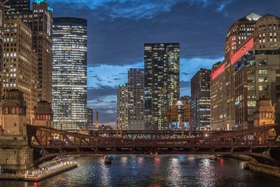 Illuminated buildings in city against sky