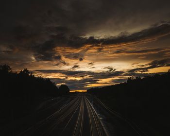 Railroad tracks against sky during sunset