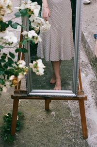 Low section of woman standing on footpath