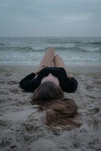 Rear view of woman relaxing on beach