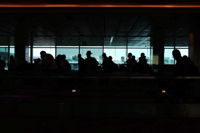 Silhouette people waiting at railroad station