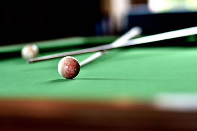 Close-up of pool balls by cue on table