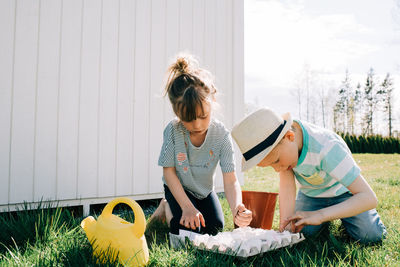 Woman and daughter on grass against plants