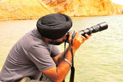 Side view of man standing by water