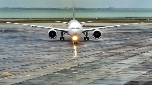 Airplane on runway against sky