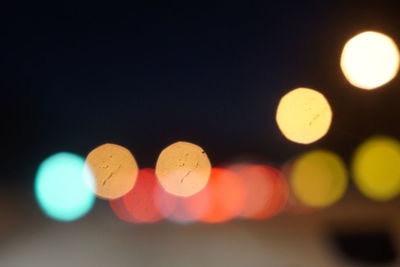 Defocused lights against sky at night