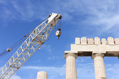 Low angle view of crane by greek temple