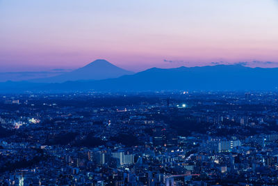 Aerial view of townscape against sky at night
