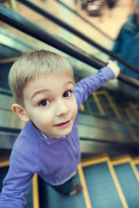 Portrait of smiling boy standing on escalator