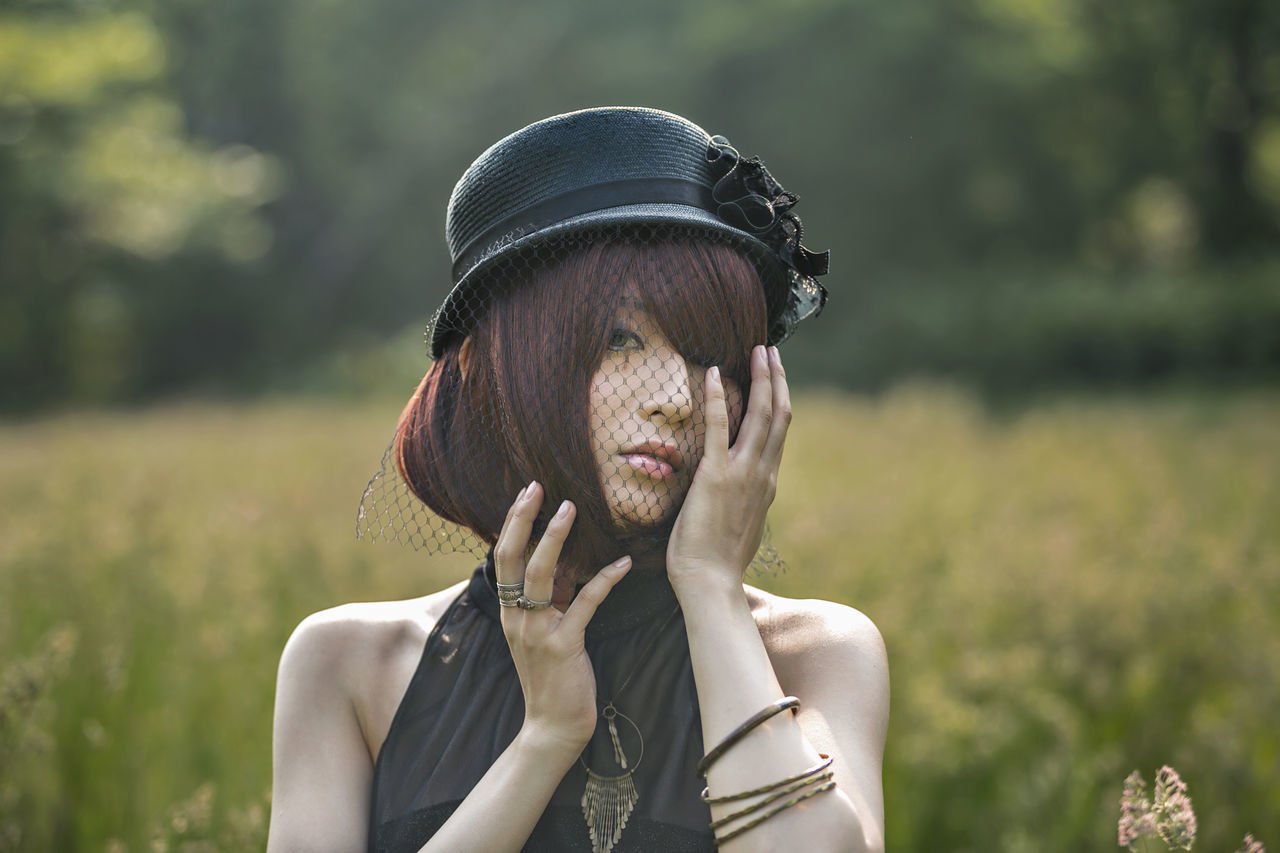 one person, real people, headshot, focus on foreground, portrait, front view, lifestyles, leisure activity, young adult, day, hat, nature, clothing, adult, young women, plant, looking, casual clothing, women, hairstyle, outdoors, human face, beautiful woman, obscured face