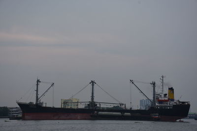 Cranes at commercial dock against sky