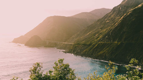 Scenic view of sea and mountains against clear sky