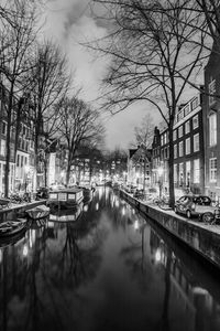 Canal amidst buildings in city against sky