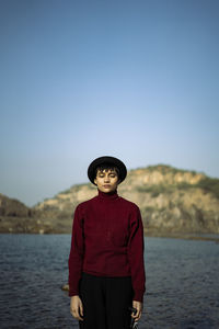 Portrait of an aesthetic looking girl wearing red sweater or sweatshirt with a black hat captured