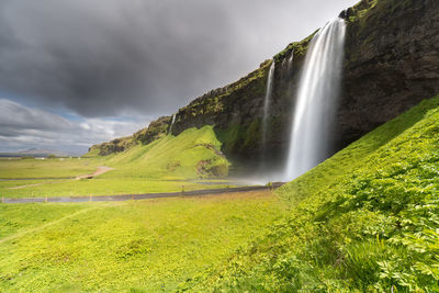Scenic view of seljalandsfoss waterfall on mountain against sky