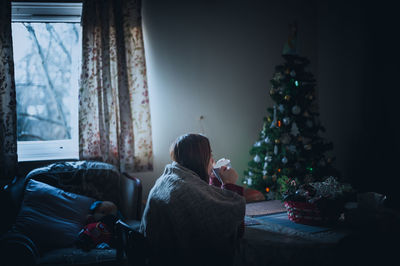 Woman drinking coffee at home during christmas