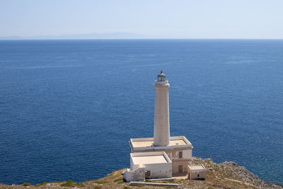 Lighthouse by sea against sky