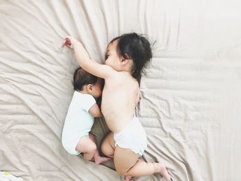 Directly above shot of babies playing on bed