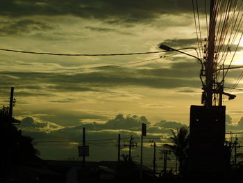 Silhouette of electricity pylon against sky during sunset